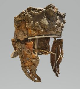 A corroded Roman cavalry helmet with two cheekpieces attached via a mount for support