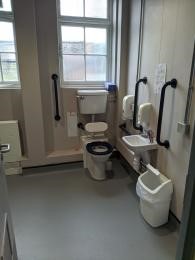 The accessible toilet, sink and grab rails.